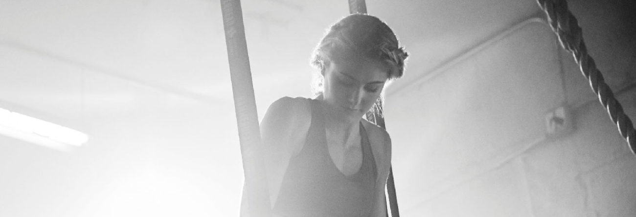 woman exercising, woman doing pull ups, black and white photo of woman exercising