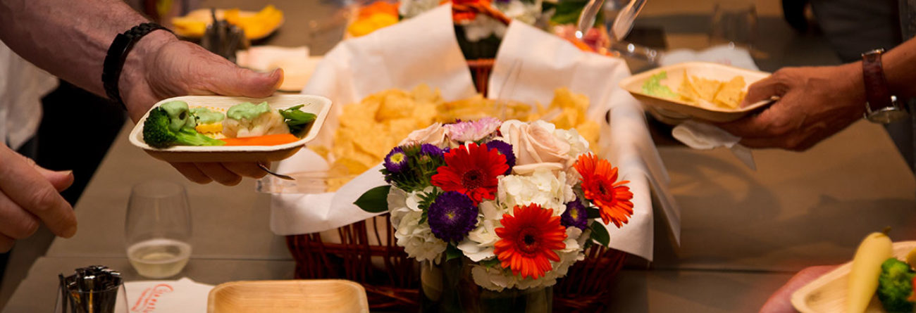 hands getting food, chips and dip, vegetables and dip